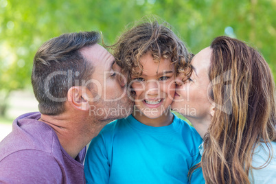 Happy family kissing at camera in the park