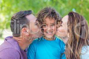Happy family kissing at camera in the park