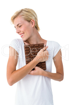Attractive woman hugging bar of chocolate