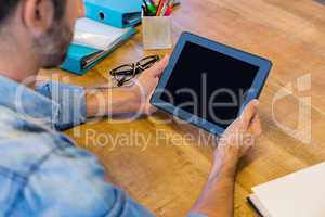 Casual businessman working at his desk with tablet