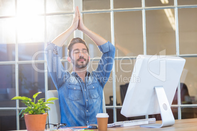 Casual businessman meditating at his desk
