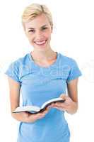Blonde woman holding bible and looking at camera