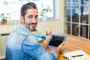 Casual businessman working at his desk with tablet