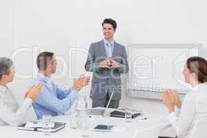 Business team applauding their colleague