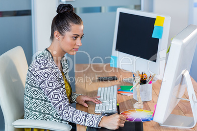 Beautiful brunette sitting at her desk and working with digitize