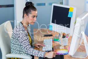 Beautiful brunette sitting at her desk and working with digitize