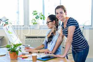 Smiling partners working together on computer