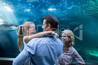 Familly enjoying behind a fish tank