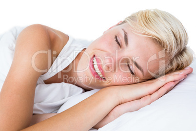 Smiling blonde woman napping in her bed Smiling blonde woman napping in her bed
