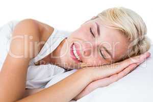 Smiling blonde woman napping in her bed