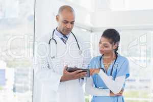 Smiling doctors working with tablet together