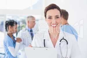 Confident female doctor holding clipboard