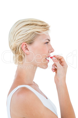 Pretty blonde woman ready to swallow red pill