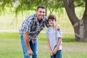 father and son smiling at camera in the park