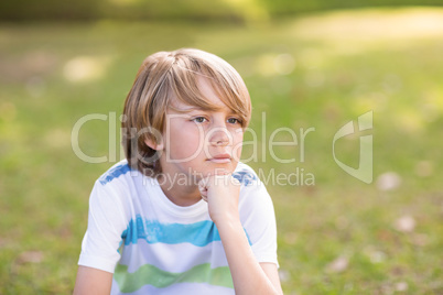 Little boy thinking in a park