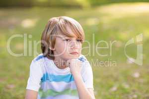 Little boy thinking in a park