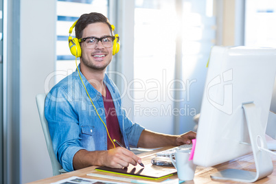 Casual businessman working with digitizer and listening music