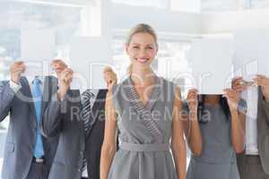 Business colleagues hiding their face with paper