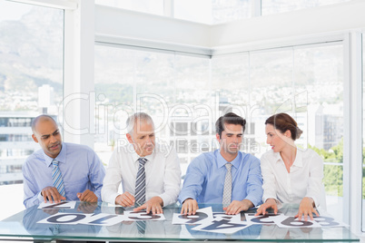 Concentrated business team sitting with their vote on the desk