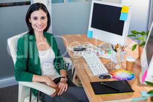 Smiling designer sitting at her desk