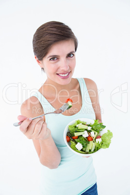 Pretty woman eating bowl of salad