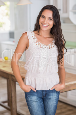 Beautiful brunette smiling at camera with hands in pockets