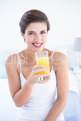 Happy woman taking drinking glass of orange juice