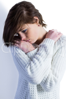 Sad pretty brunette thinking with arms crossed