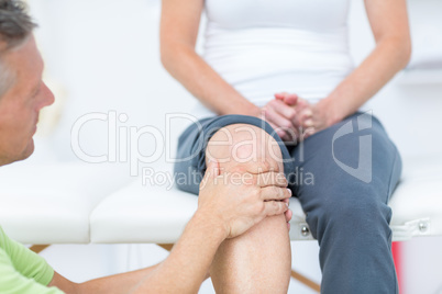 Doctor examining his patients knee