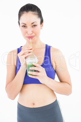 Attractive woman drinking green juice