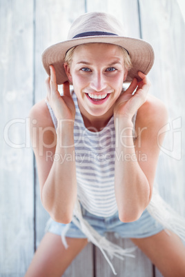 Pretty blonde woman wearing hat and smiling at camera