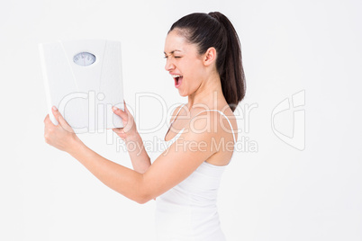 Fit woman holding weighing scales