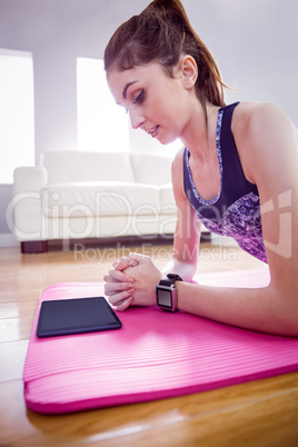 Fit woman doing plank on mat