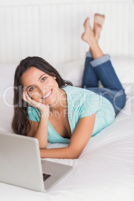 Happy brunette using her laptop