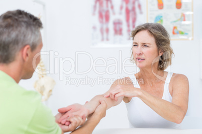 Doctor examining his patients arm