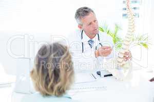 Doctor showing spine model to his patient