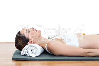 Relaxed brunette lying on mat with stones Relaxed brunette lying on mat with stones