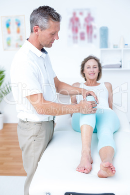 Physiotherapist examining his patients knee