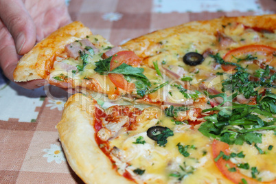 man takes a piece of tasty pizza from plate