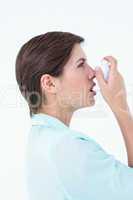 Pretty woman using her inhaler