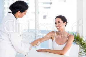 Doctor looking at her patients arm