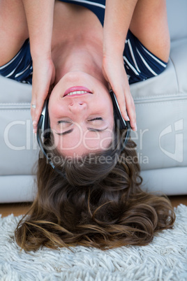 Pretty brunette listening music on couch