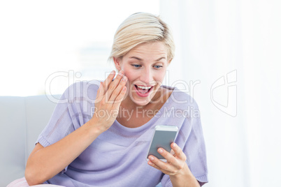 Pretty blonde woman texting with her mobile phone