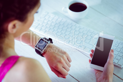 Woman using her smartwatch and phone