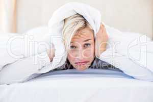 Upset blonde woman lying on the bed