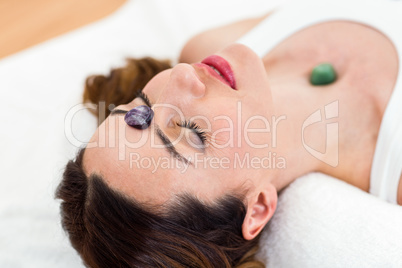 Relaxed brunette lying on mat with stones