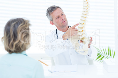 Doctor showing spine model to his patient