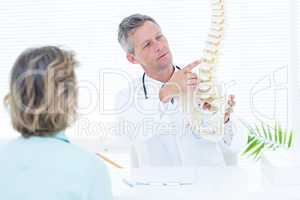 Doctor showing spine model to his patient