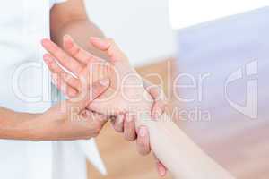 Physiotherapist massaging her patients hand
