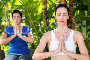 Relaxed woman and her trainer doing yoga